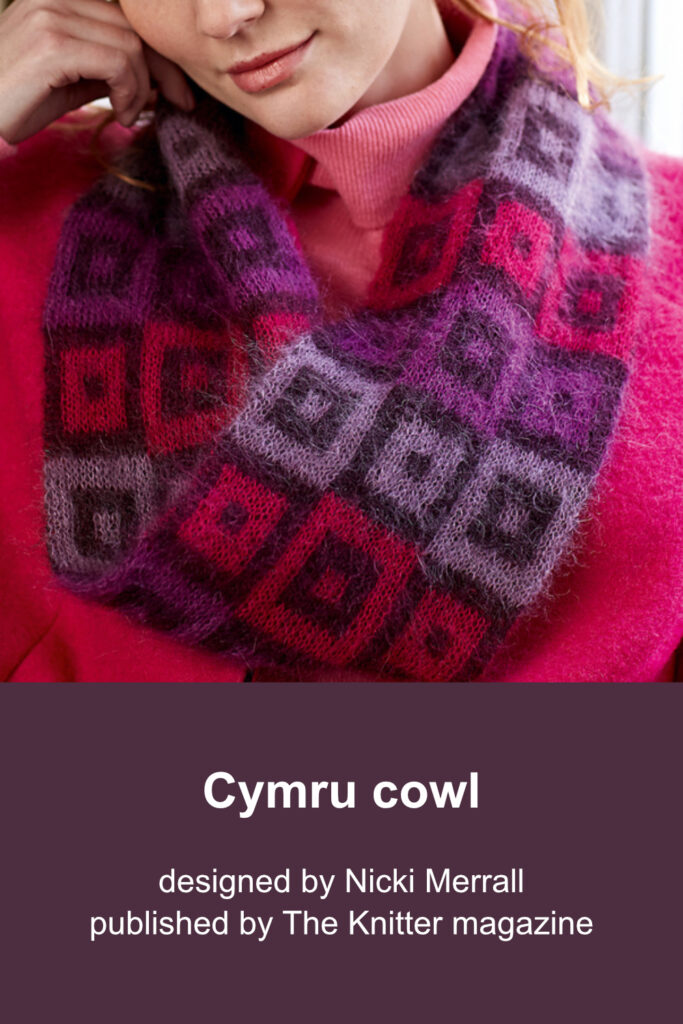 Woman wearing hand-knit purple and pink cowl with a grid pattern