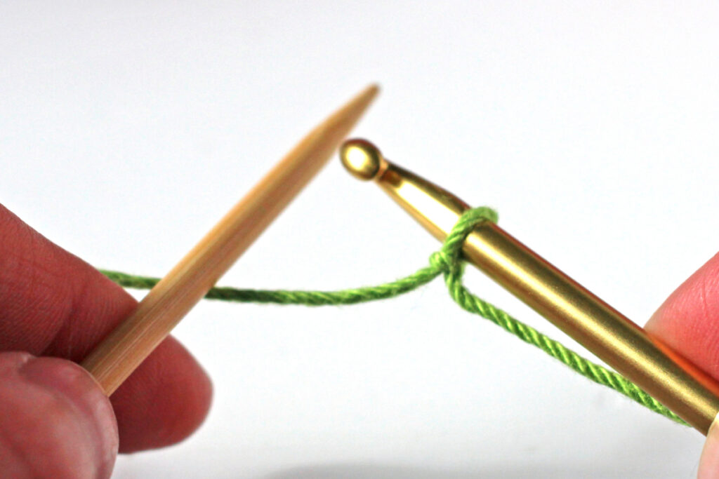 Start crochet cast-on with hook in dominant hand and knitting needle in non-dominant hand