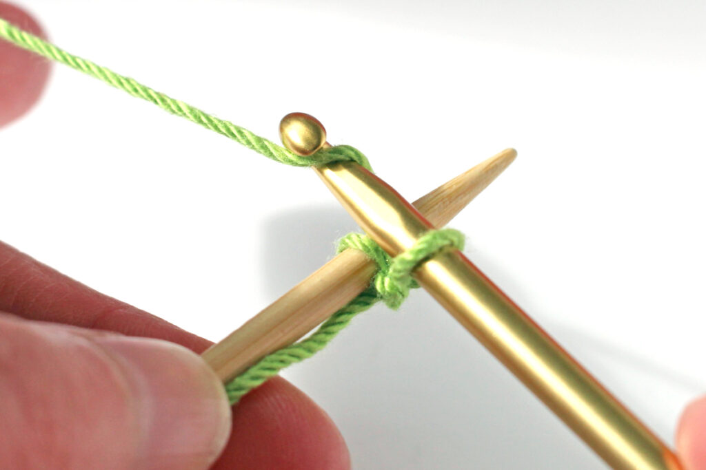Pass crochet hook over knitting needle again