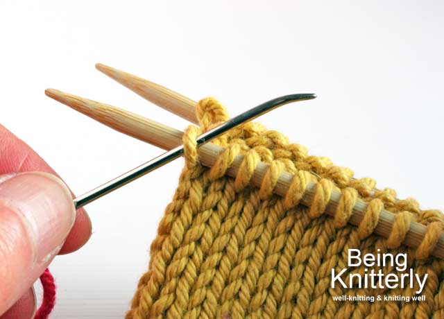 Step 2: Pass yarn needle purlwise through first stitch on front needle