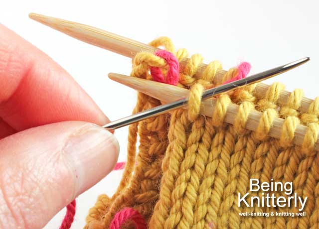 Step 8: Pass yarn needle purlwise through next stitch on front needle