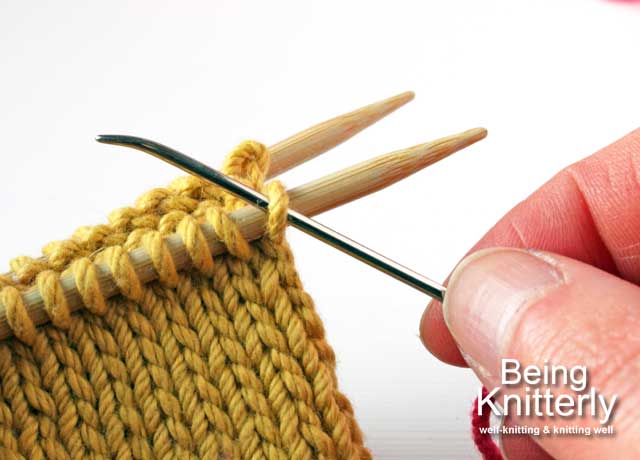 Set-up step 1a: Pass yarn needle purlwise through first stitch on front needle