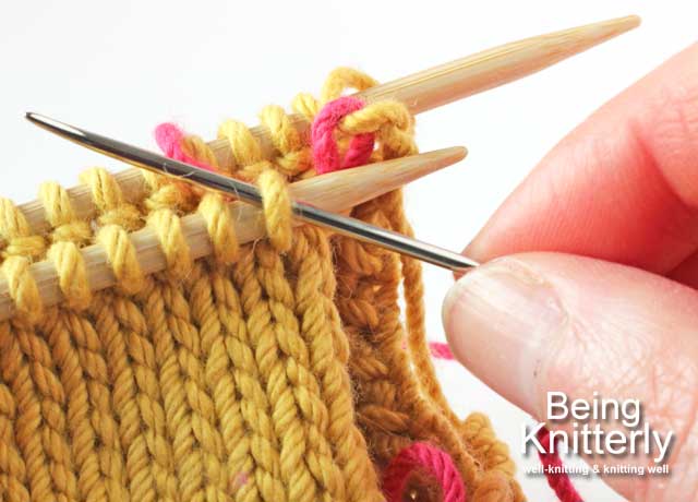 Stitching step 2a: Pass yarn needle purlwise through next stitch on front needle
