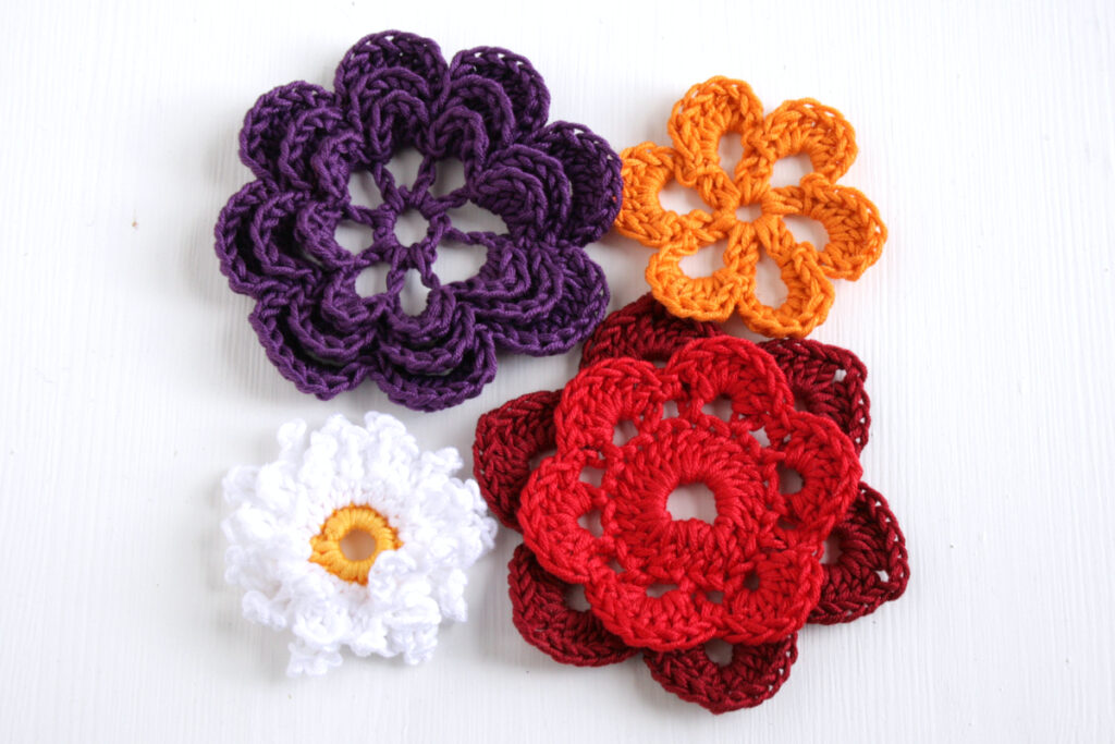 Four crochet flowers made using different colours and techniques.