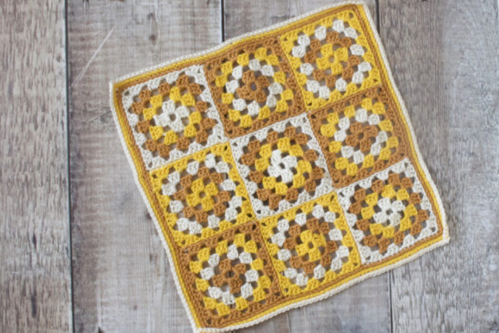 Small blanket made from yellow, cream and gold granny squares.