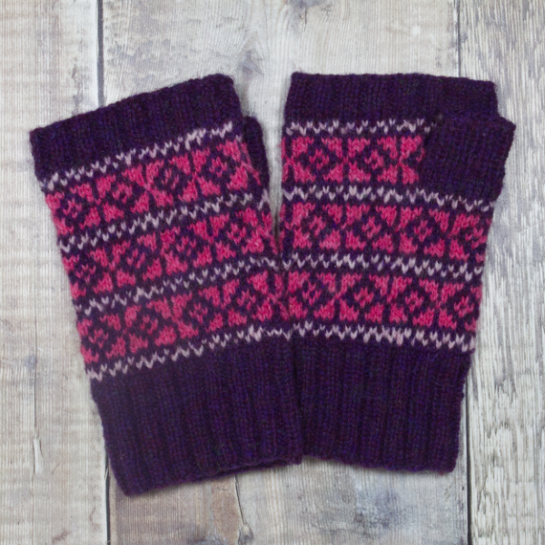 Deep red-violet fingerless mittens with small Fair Isle patterns in pale and medium pink over the hand